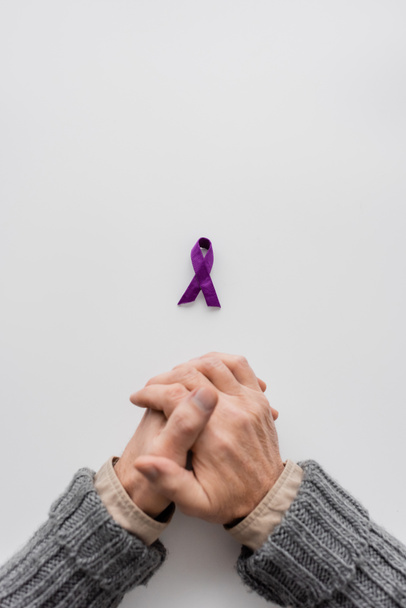 top view of cropped senior man near purple alzheimer disease awareness ribbon on white background with copy space - Zdjęcie, obraz