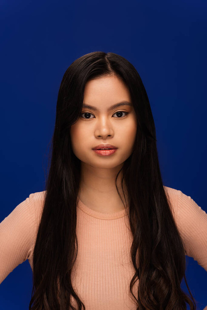 Portrait of long haired asian model isolated on navy blue - Fotó, kép