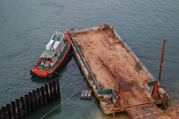Tugboat and a barge or flat bottomed vessel parking at the sea side ready for load. - Fotó, kép