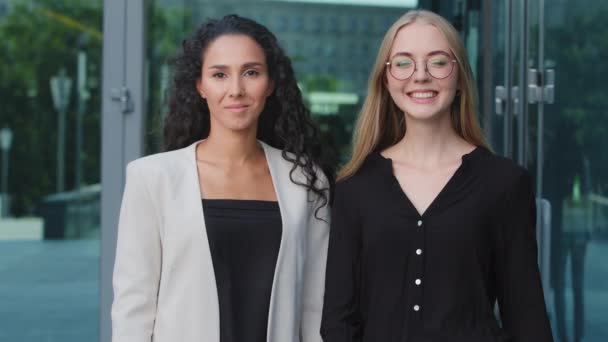 Responsible colleagues young female managers, bank employees in formal clothes posing outdoor. Portrait of two modern confident independent business women, professional leaders, coaches for executives - Filmagem, Vídeo