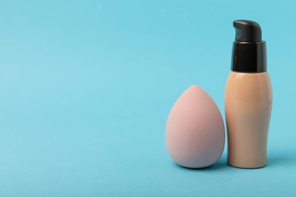 Beauty blender and tannal cream, concealer on a blue background. Bright sponges for cosmetics. Makeup products. Beauty concept. Place for text. Place to copy. flat lay - Photo, image