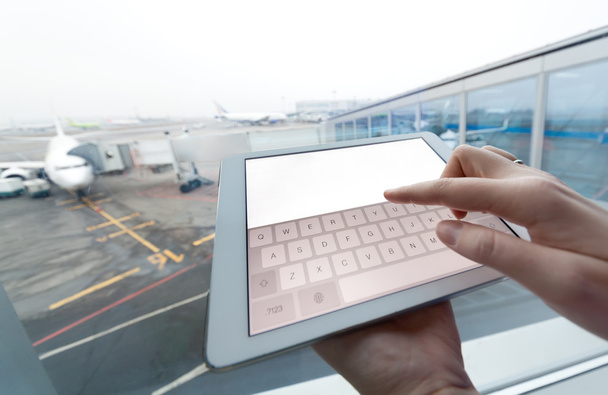 Mujer con tablet PC pantalla vacía en el aeropuerto
 - Foto, imagen