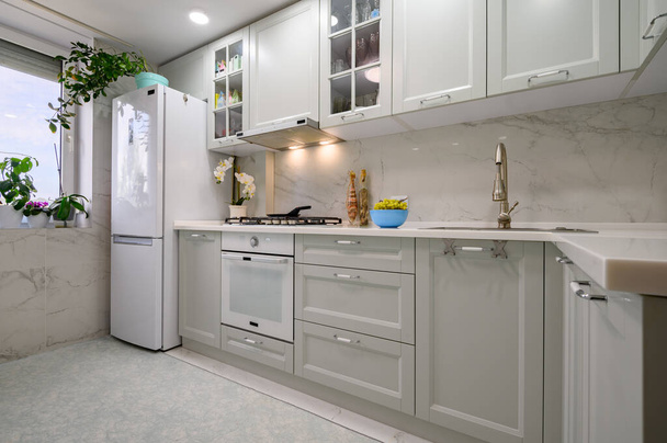 Новый светло-серый современный дизайн интерьера кухни после ремонта - Фото, изображение