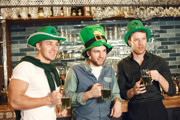 Men in green hats. Friends celebrate St. Patricks Day. Celebration in a pub. - Valokuva, kuva