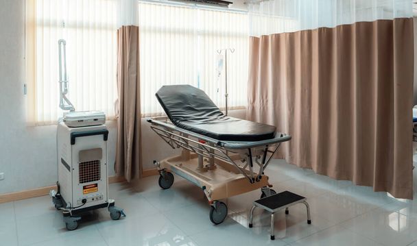 Rahatlatıcı modern hasta yatağı ile donatılmış steril tedavi odası. Hastanenin yatak odası ya da koğuşunun fotoğrafı.. - Fotoğraf, Görsel