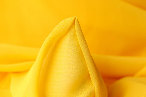 Shaped yellow fabric as bckground. Element of bright yellow textile close up. - Foto, afbeelding