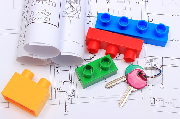 Ключи от дома, строительные блоки и электропроводка на чертежах дома
 - Фото, изображение