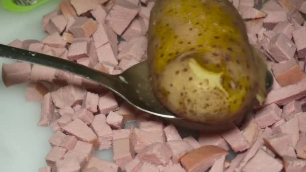 the cook's hand checks with a toothpick a boiled potato in a peel over a boiled sausage, close-up. - Filmmaterial, Video