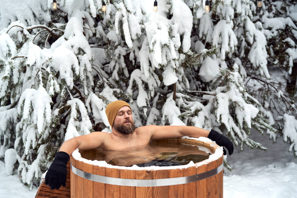 Caucasian man take the winter bath in tube outdoors - Foto, imagen