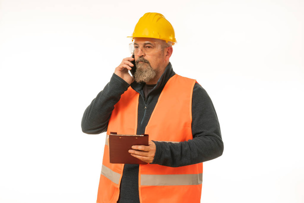 Professional engineer inspector foreman at work , construction manager working in manufacturing technology, man at work concept, on white background in yellow helmet and orange vest. - Photo, Image