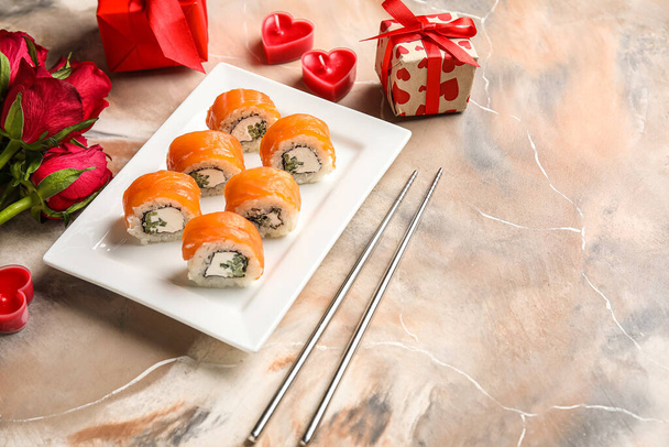 Plate with sushi rolls, chopsticks, gifts and roses on grunge background. Valentine's Day celebration - Fotó, kép