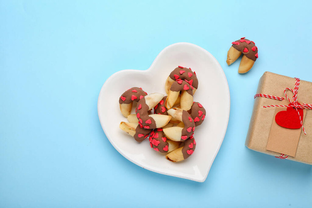 Plate of fortune cookies with gift on blue background. Valentine's Day celebration - Foto, Imagem