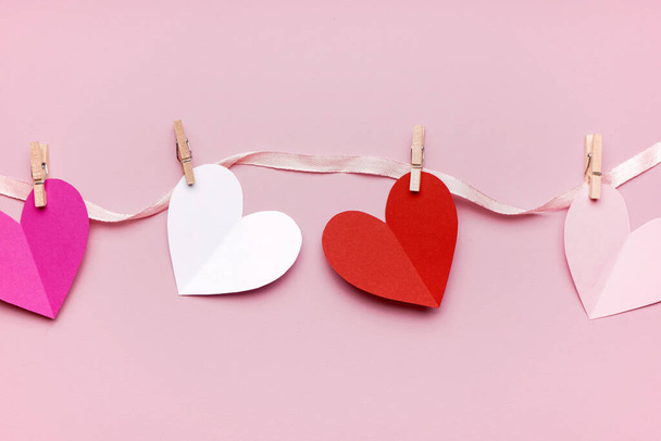 Σύνθεση με χάρτινες καρδιές σε ροζ φόντο. Γιορτή του Αγίου Βαλεντίνου - Φωτογραφία, εικόνα