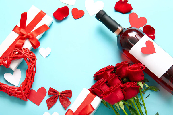 Frame made of wine bottle, rose flowers, gifts and hearts on blue background. Valentine's Day celebration - Foto, imagen