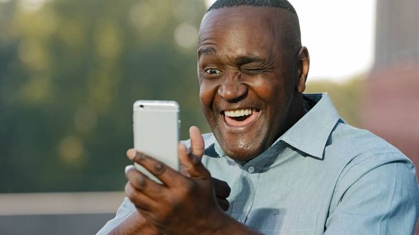 Ηλικιωμένοι ηλικιωμένοι ώριμοι Αφροαμερικανοί μιλούν με το συνέδριο συνομιλίας smartphone μιλώντας εικονική συνάντηση μεσήλικες vlogger γυρίσματα βίντεο μερίδιο ειδήσεων αρσενικό επιχειρηματίας με κινητό τηλέφωνο app μιλούν - Φωτογραφία, εικόνα