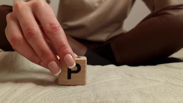 Woman composes the word PMS from wooden blocks. Premenstrual syndrome concept - Filmati, video