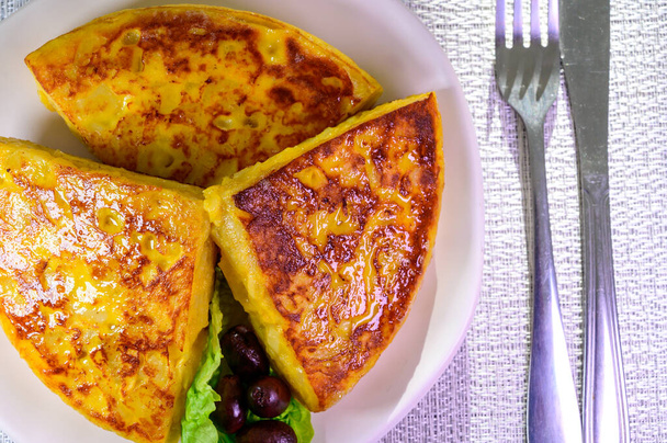 Spanish vegetarian food, portion of homemade tasty potato omelette tortilla de patatas with onion served on terrace in morning sunlights - Foto, imagen