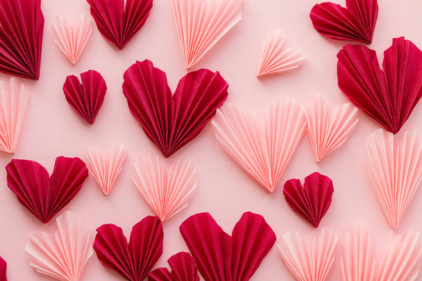 День Святого Валентина плоский лежав. Стильна композиція рожевих і червоних сердець на фоні рожевого паперу. Творчі сучасні валентинки сердечка вирізані. Любовний фон. З днем Святого Валентина
 - Фото, зображення