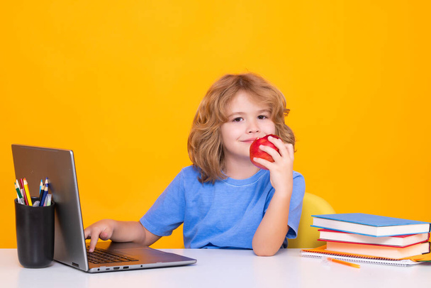 ラップトップコンピュータを使用して学校の子供。学校と子供たち。本の勉強で可愛い金髪の子供。知識の日 - 写真・画像