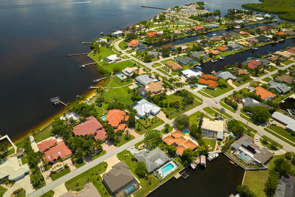 Vista aérea de suburbios residenciales con casas privadas ubicadas en la costa del golfo cerca de humedales de vida silvestre con vegetación verde en la orilla del mar. Vivir cerca del concepto de naturaleza. - Foto, imagen
