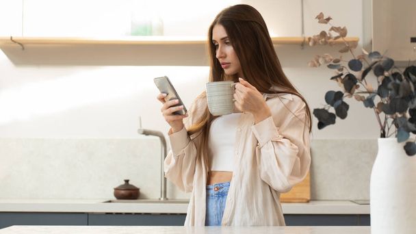 Une jeune femme brune utilise son téléphone lors de ses achats en ligne. Surfer sur Internet, les réseaux sociaux. - Photo, image