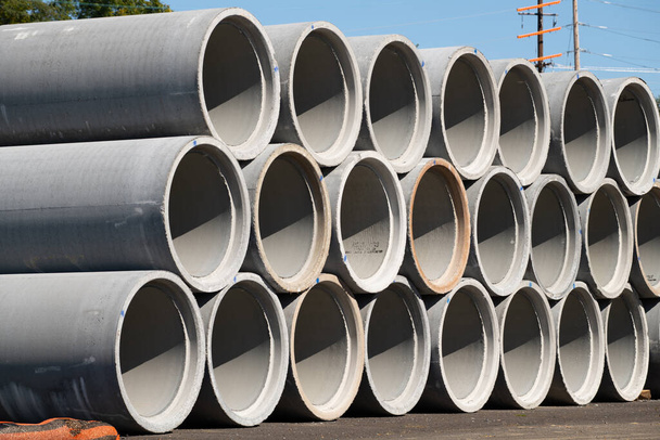 Reinforced concrete storm sewer pipes stacked at a construction site large diameter pipes stack - Photo, Image