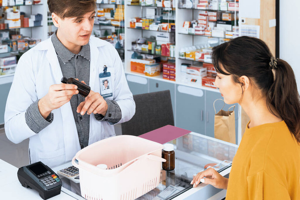 Professional pharmacist advise or explain property of qualified medical product to customer in pharmacy, druggist answer to client healthcare inquiry, medical service and consultation concept. - Photo, Image