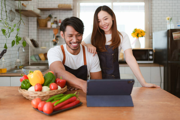 Портрет молодой азиатской пары, готовящей салат вместе дома. приготовление пищи и образ жизни момент и здоровый. - Фото, изображение