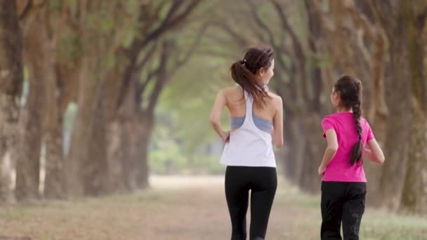 Rückansicht Mutter und Tochter joggen im Park - Filmmaterial, Video