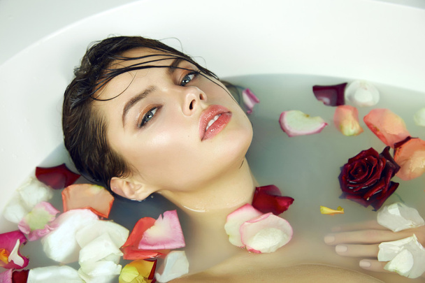 Beautiful sexy woman takes bath rose candles Valentine's day spa - Foto, afbeelding