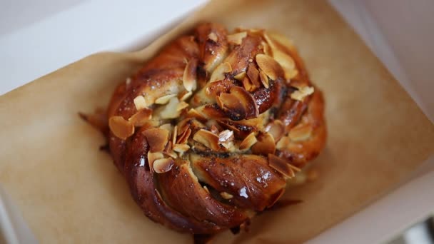 Traditional sweet swedish homemade puff pastry cinnamon rolls with almonds placed in paper box - Filmagem, Vídeo