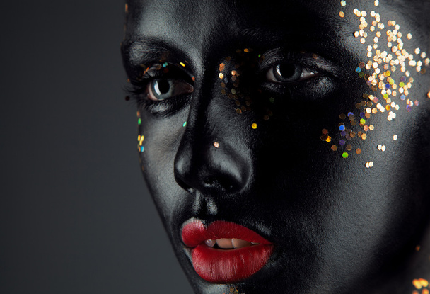 Art make up.Woman portrait with creative make up, black face, re - Valokuva, kuva