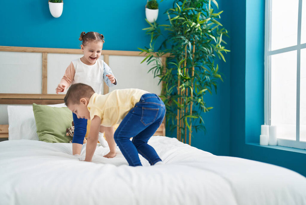 Two kids smiling confident jumping on bed at bedroom - Foto, imagen