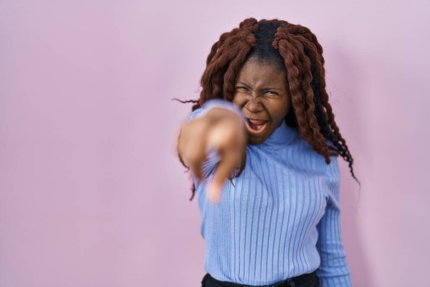 African woman standing over pink background pointing displeased and frustrated to the camera, angry and furious with you  - Фото, зображення