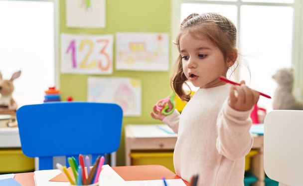 Adorable hispanic girl playing with toys standing at kindergarten - Foto, imagen