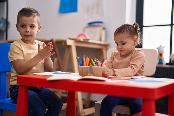 Two kids preschool students sitting on table drawing on paper at kindergarten - Photo, Image