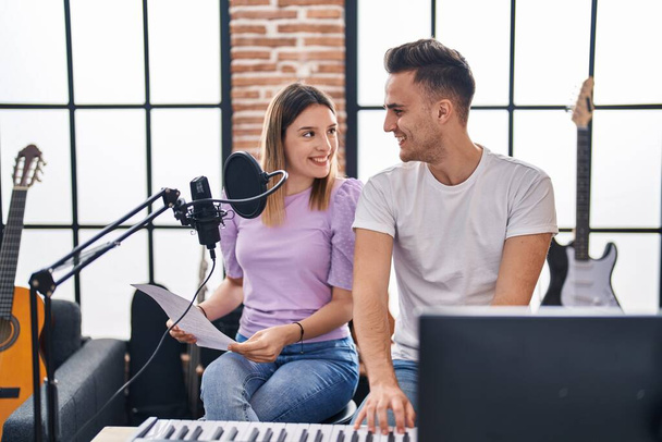 Man and woman musicians singing song playing piano at music studio - Foto, afbeelding