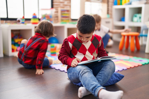 Zwei Kinder lesen Buch auf dem Fußboden im Kindergarten - Foto, Bild