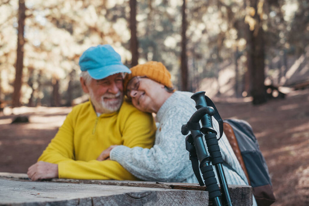 Head shot portrait close up of cute couple of old middle age people having fun and enjoying together in the forest of the mountain at the table relaxing and resting - Photo, Image