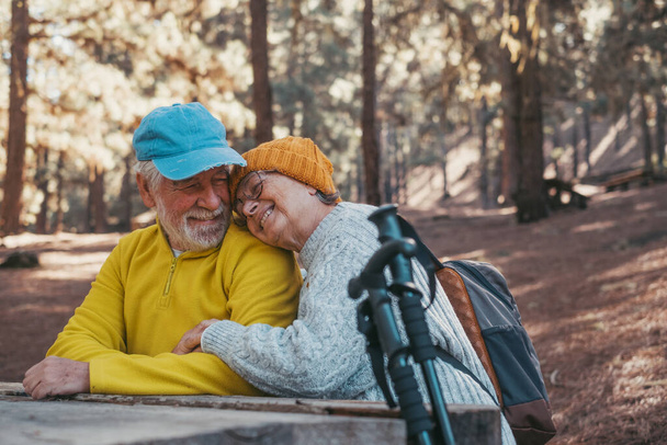Head shot portrait close up of cute couple of old middle age people having fun and enjoying together in the forest of the mountain at the table relaxing and resting - Zdjęcie, obraz