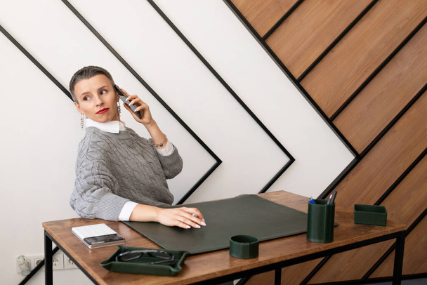 Mujer de negocios con corte de pelo corto hablando por teléfono en la oficina. - Foto, Imagen