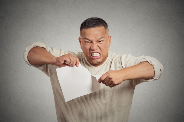  angry man tearing document to pieces isolated on grey background  - Foto, immagini
