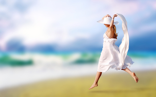 Young beautiful women in the white on the sunny tropical beach - Фото, изображение