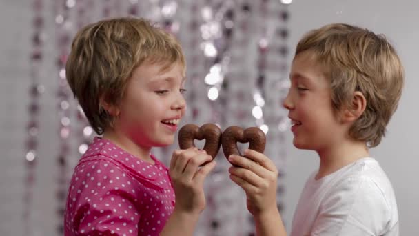 Gingerbread in the shape of hearts in the hands of girl and boy. Medium shot - Metraje, vídeo
