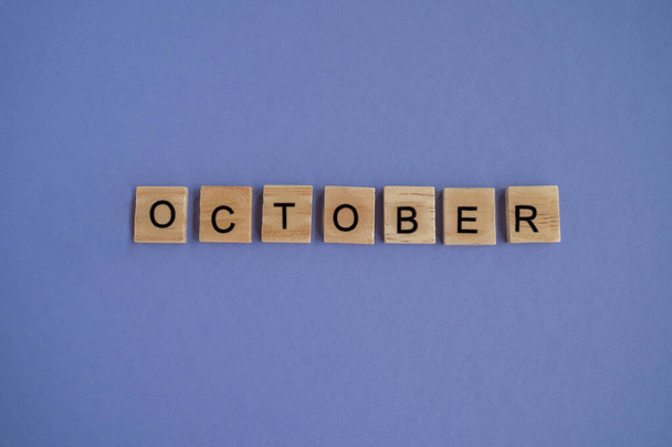 Δέκατος μήνας του έτους Οκτώβριος - από μεμονωμένα γράμματα σε ξύλινα τουβλάκια σε φυσικό χρώμα, σε υψηλή ανάλυση. Πολύ Peri Χρώμα της Χρονιάς φόντο, αντίγραφο χώρου. Επίπεδο lay, βήμα προς βήμα, βήμα 10. - Φωτογραφία, εικόνα