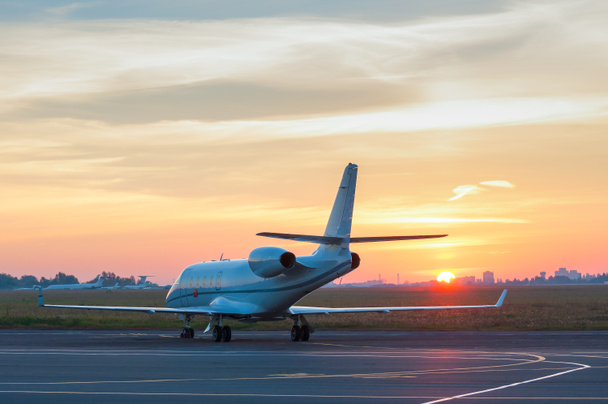 Business jet on the apron of aircraft. Dawn at airport - Photo, Image