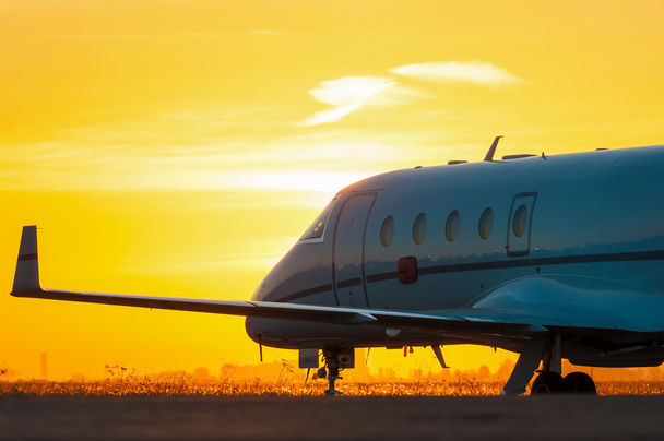 Business jet on the apron of aircraft. Dawn at airport - Photo, Image