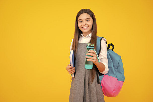Back to school. Schoolgirl with bottle of water. Drinking regime. Teenager student - Foto, imagen