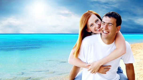 Jonge liefde paar glimlachend onder tropisch strand - Foto, afbeelding
