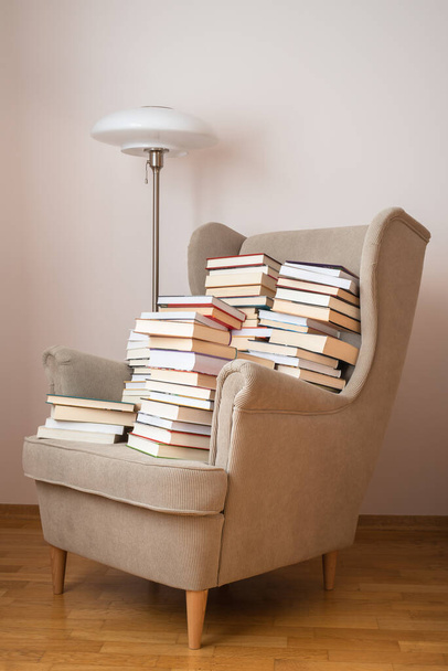 Pile of books on an armchair in reading room - Valokuva, kuva